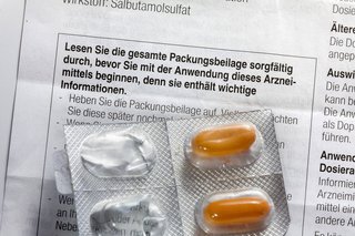 Ein Beipackzettel, darauf ein Blister mit Tabletten