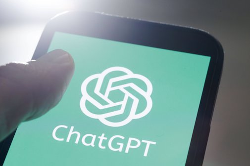 ChatGPT Jemand hält ein Smartphone, auf dem Display sieht man das Logo von ChatGPT