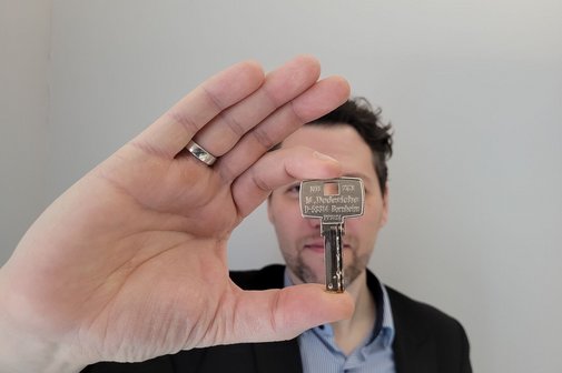Ein Mann h&auml;lt den Euroschl&uuml;ssel f&uuml;r Behindertentoiletten in der Hand. 