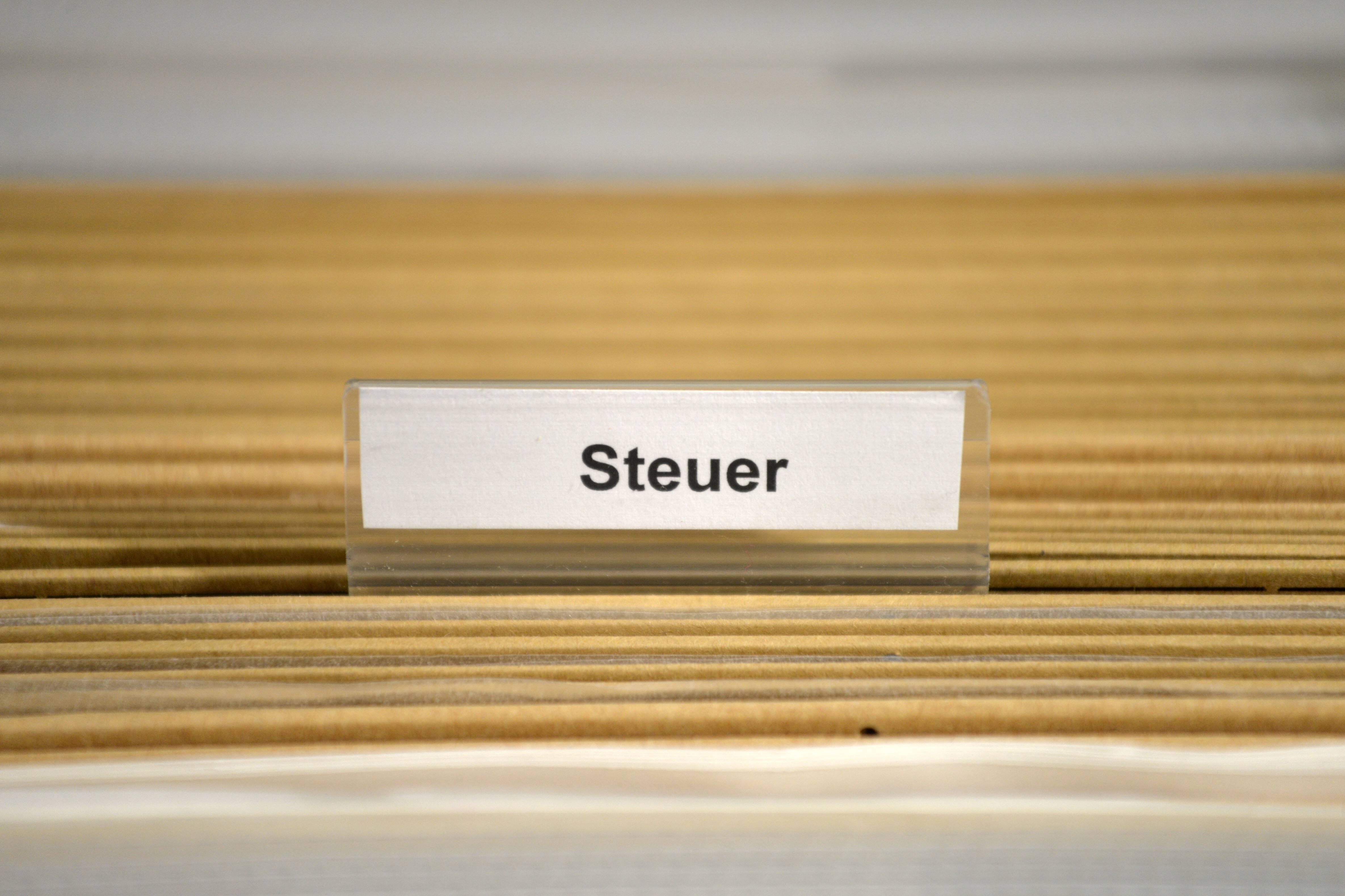Steuer-Unterlagen Mappen sind zu sehen, auf einer ist ein Reiter festgesteckt mit dem Wort Steuer.