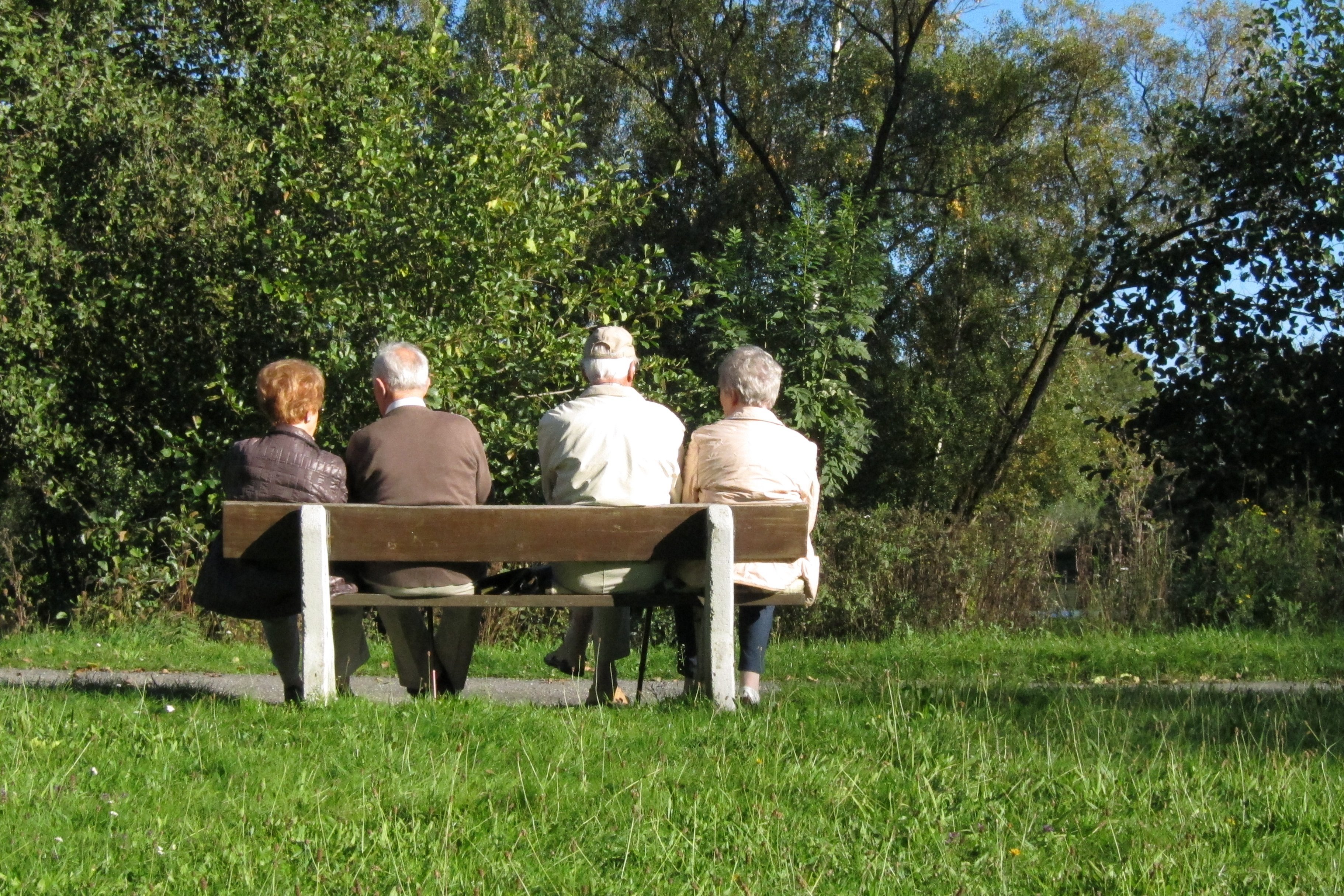 Vier Menschen sitzen auf einer Bank