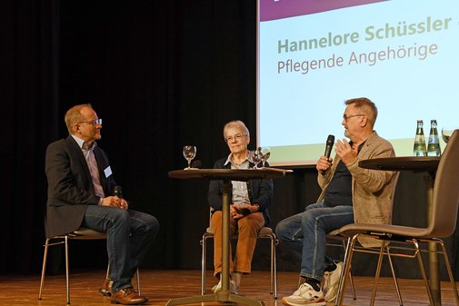 Zwei M&auml;nner und eine Frau im Gespr&auml;ch