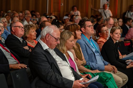 Blick auf die erste Reihe im gutgefüllten Saal. 