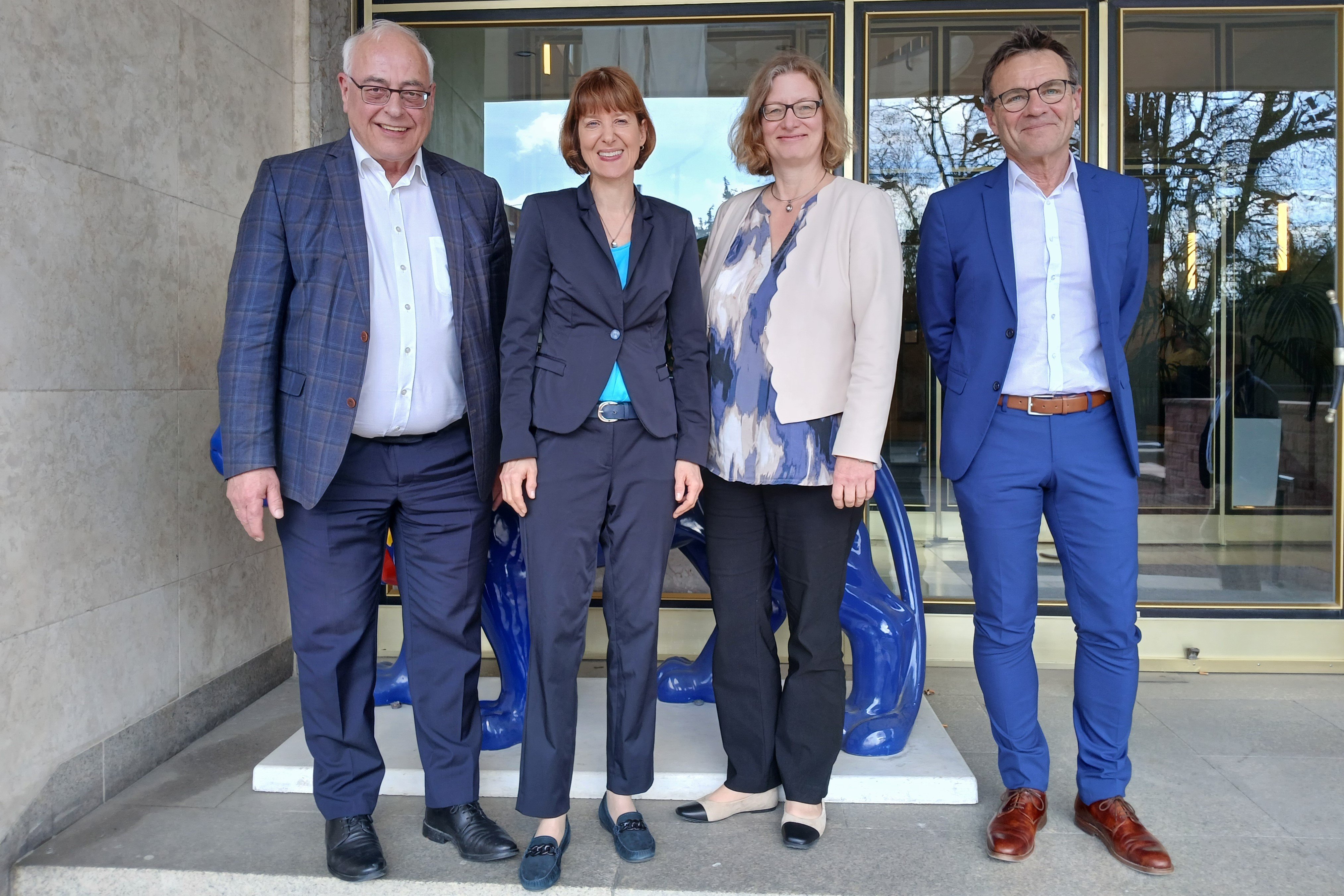 Viererreihe: Zwei Männer auf den Außenposten, zwischen sich die Ministerin und ihre Staatssekretärin.
