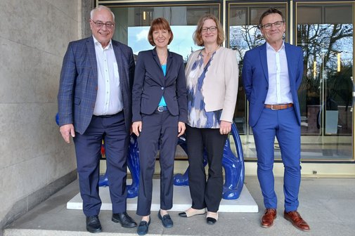 Viererreihe: Zwei Männer auf den Außenposten, zwischen sich die Ministerin und ihre Staatssekretärin.