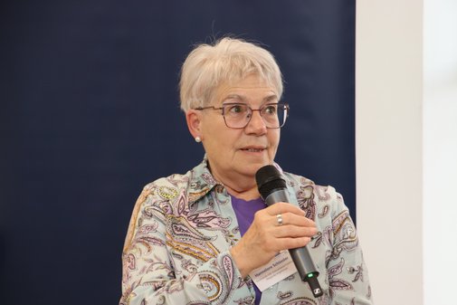 Frau mit grauem Bubikopf schildert aus eigener Erfahrung den Alltag einer pflegenden Angehörigen. 