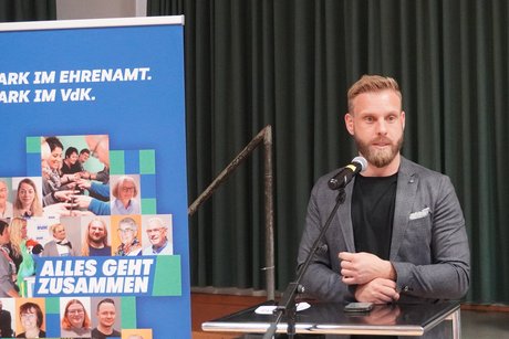 J&uuml;ngerer Mann mit Vollbart spricht ein Gru&szlig;wort. 