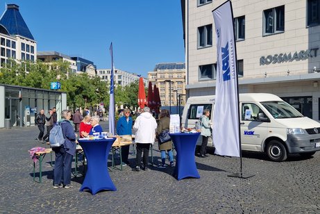 Mehrere Menschen an einem infostand