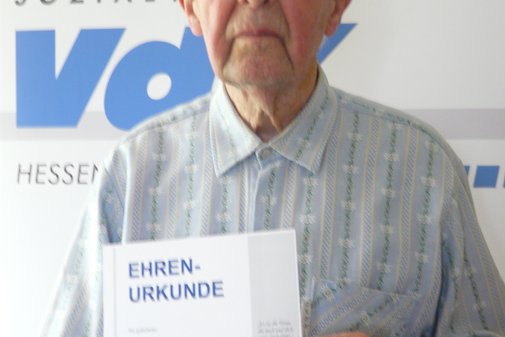 Sehr alter Mann präsentiert Urkunde