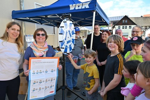 Mehrere Erwachsene und Kinder an einem Informationsstand