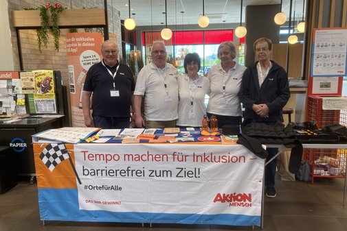 Fünf Menschen an einem Informationsstand