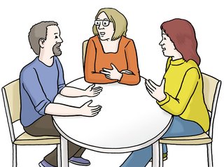 Drei Personen sitzen an einem Tisch und diskutieren.