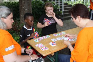 Zwei Erwachsene und zwei Kinder beim Kartenspielen