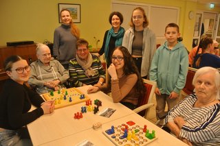 Jugendliche und ältere Menschen beim Spiel