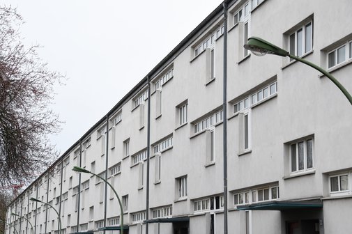Ein wei&szlig; angestrichener Wohnblock mit drei Stockwerken