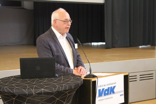 Eine Mann steht an einem Pult und h&auml;lt eine Rede