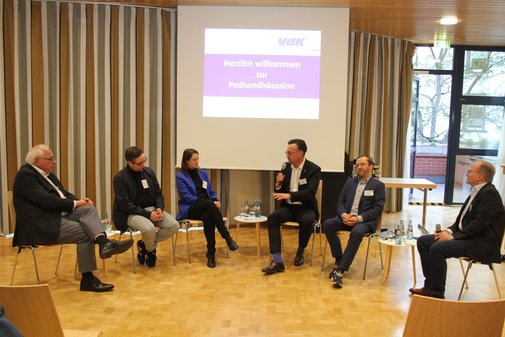 Mehrere Menschen sitzen im Halbkreis und sprechen miteinander