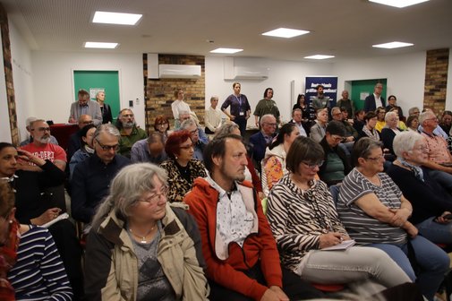 Blich in den Saal. Alle Stühle sind besetzt, im Hintergrund stehen mehrere Leute, die keinen Stuhl mehr abbekommen haben. 