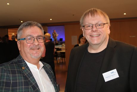 Zwei Männer mit Brille schauen in die Kamera