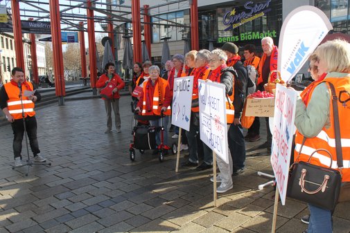 Ein Mann hält vor mehreren Menschen eine Rede