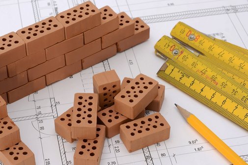 Backsteine, Zollstock und Bauplan