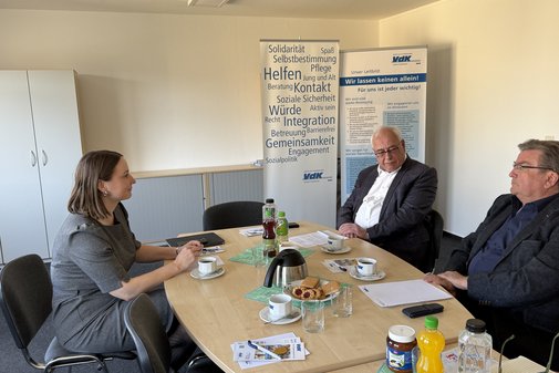 Großer ovaler Tisch, im Hintergrund VdK-Roll-ups. Auf der linken Seite die Ministerin, ihr gegenüber der VdK-Landesvorsitzende Weimann und sein Stellvertreter Kubitzki.