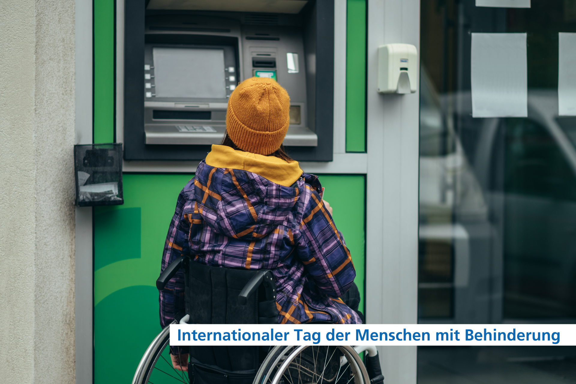 Eine Frau im Rollstuhl steht vor einem Geldautomat. Dieser ist zu hoch f&uuml;r sie. Das Eingabefeld ist auf der H&ouml;he ihres Kinns.