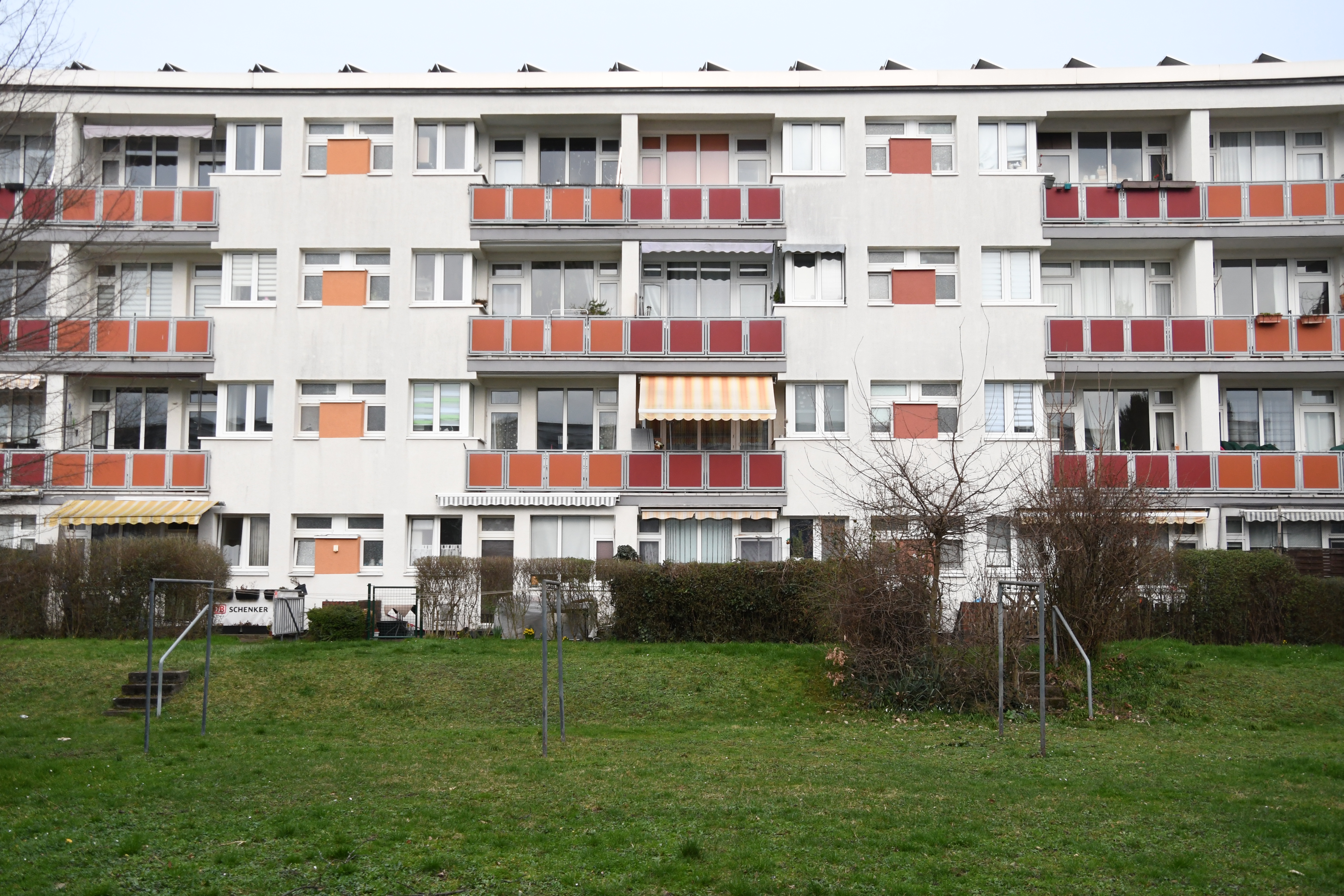Blick auf einen Wohnblock mit etwa 20 Wohnungen. Im Vordergrund eine Gr&uuml;nanlage. 