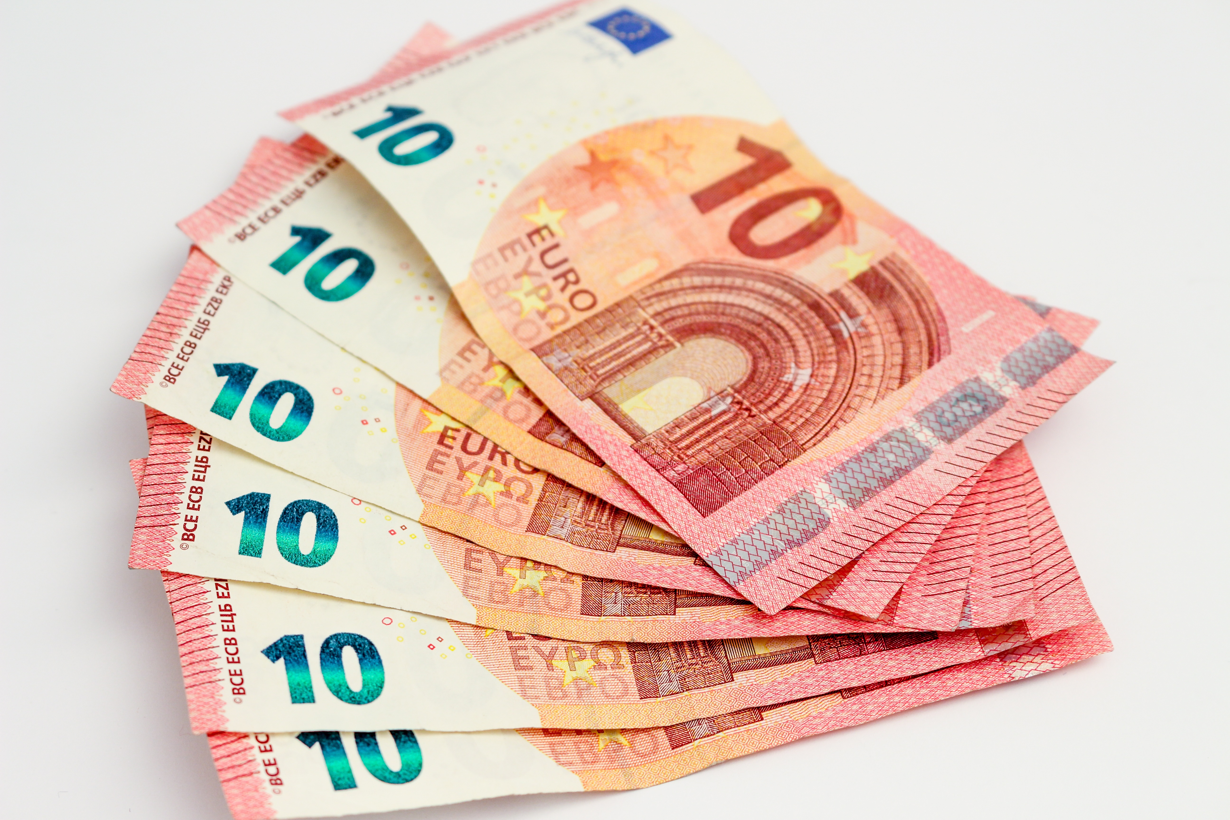 Frühstartrente Sechs Zehn-Euro-Scheine sind vor weißem Hintergrund fächerartig angeordnet.
