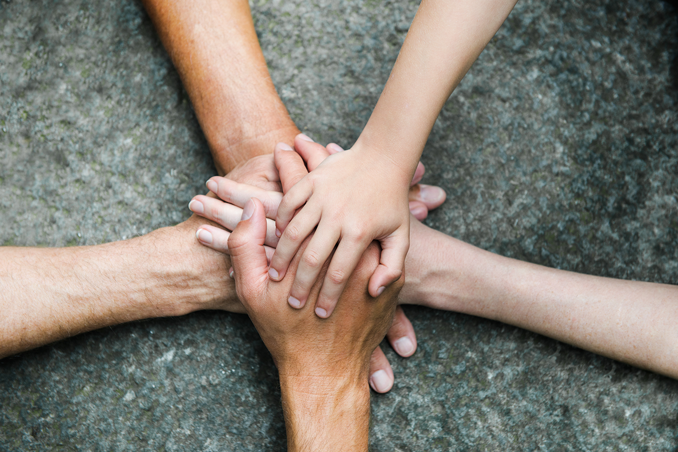 F&uuml;nf Personen legen jeweils eine Hand aufeinander, so dass ein Kreis bzw. ein Stern entsteht