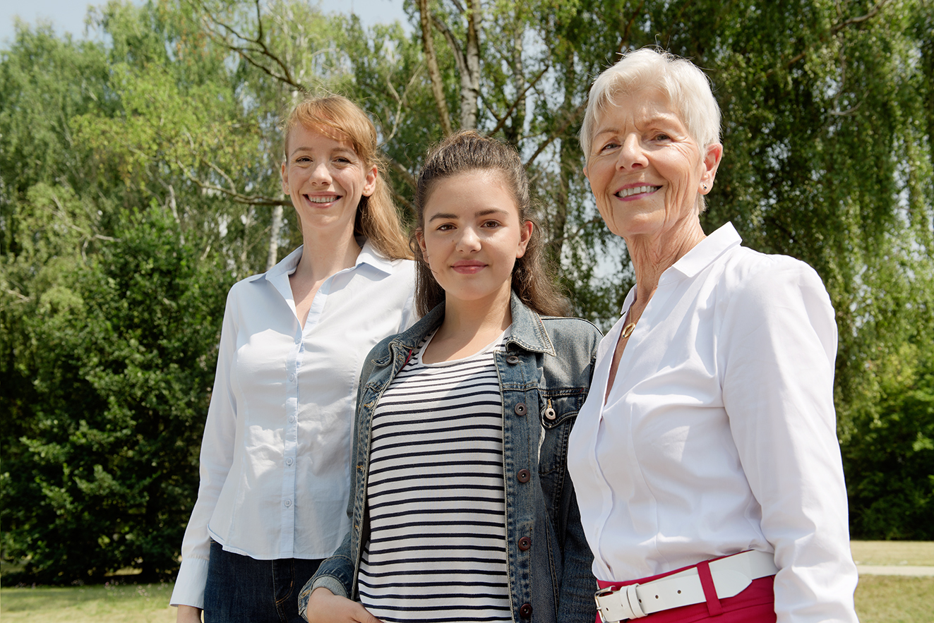 Frauen aus drei Generationen Drei Frauen lächeln gemeinsam in die Kamera: Eine jüngere, eine Teenagerin und eine ältere Frau.