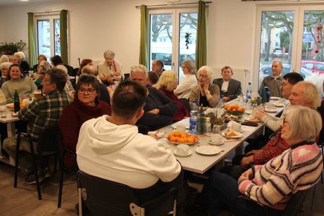 Mehrere Tische, alle voll besetzt mit &uuml;berwiegend &auml;lteren Vereinsmitgliedern. Blick von rechst.