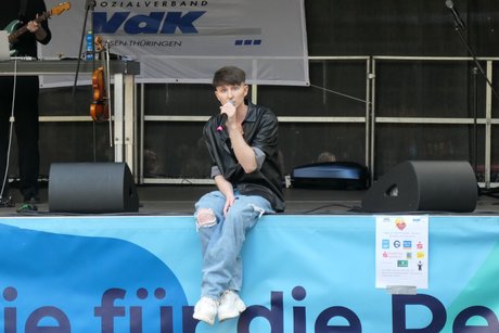 Der Sänger Maksim sitzt auf dem Rand der Bühne