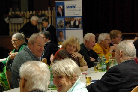 Mitglieder sitzen am Tisch und führen Gespräche