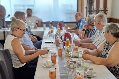 Die G&auml;ste sitzen am Tisch.