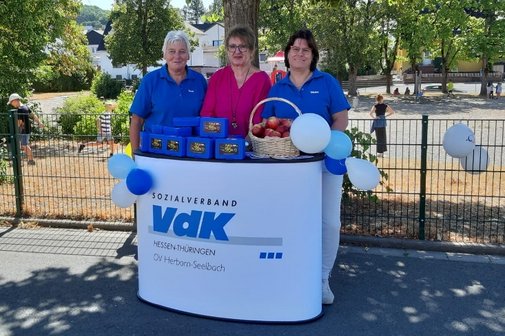 Auf dem Bild sehen wir 3 damen vom VdK Herbornseelbach an einem Stand mit Einschulungsgeschenken.