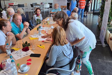 75 Jahrfeier des VDK OV-Mörfelden / Quizfragen Diana Lorei beim Verteilen von Papier und Kugelschreiber und Einteilen der Tischgruppen