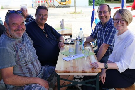 Sozialdezernentin Dr. Patricia Becher sitzt mit Vertretern des VdK, von Ideen für Biebrich und des Weissen Rings beim Grillnachmittag an einem Tisch.
