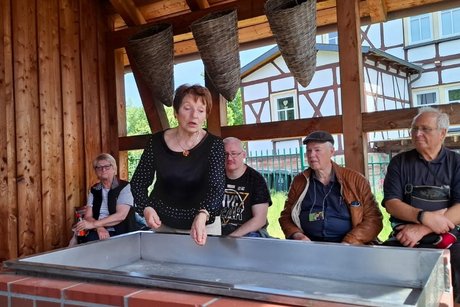 Monika Scharfenberg erklärt mit einer Geste das Salzsieden.