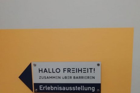 Ausstellungsschild "Hallo Freiheit - Zusammen über Barrieren"