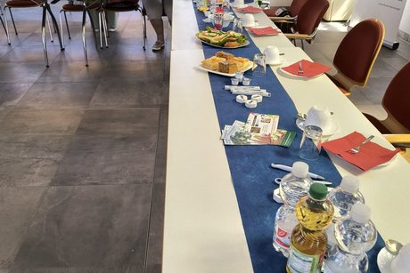 Eine mit Kaffee, Kuchen, Getr&auml;nke und belegte Br&ouml;tchen gedeckte Tafel.