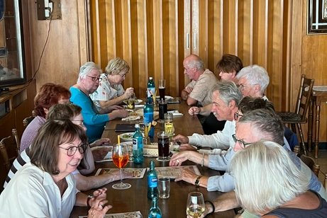 Auf dem Bild sieht man eine gesellige Runde beim VdK-Babbelabend. Mehrere Teilnehmerinnen und Teilnehmer sitzen gemeinsam an einem langen Tisch in gemütlicher Atmosphäre. Es wird miteinander gesprochen, gelacht und gegessen; auf dem Tisch stehen Getränke und Speisekarten. Die Aufnahme vermittelt besonders schön die offene und freundschaftliche Stimmung der Runde – genau das, was einen Babbelabend ausmacht: zusammenkommen, sich austauschen, viel Spaß haben und voneinander lernen.