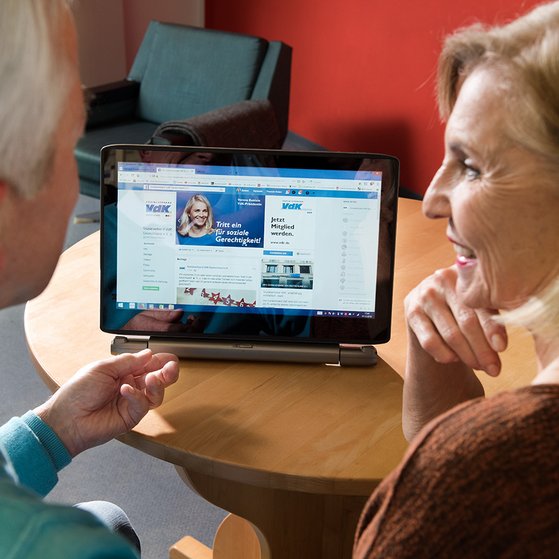 Ein &auml;lteres Paar am Computer, auf dem Bildschirm sieht man die Facebook-Seite des VdK Deutschland
