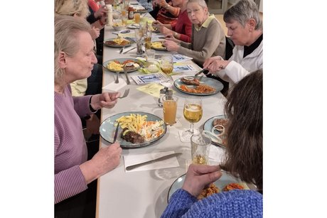 Stammtisch Liederbachhalle mehrere personen sitzen an einer langen tafel und essen