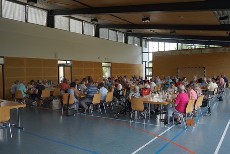 Alle sitzen wieder an ihren Plätzen und genießen Spießbraten oder Hähnchenschenkel.