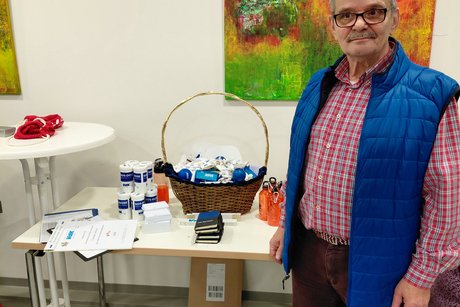 Der Vorsitzender Rolf Leipold am Tisch mit verschiedenen Mitnehm-Artikel von VdK