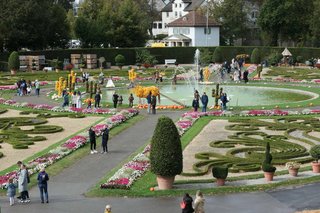 Um eine Springbrunnen stehen Figuren aus Kürbissen, umgeben vom Barockgarten.