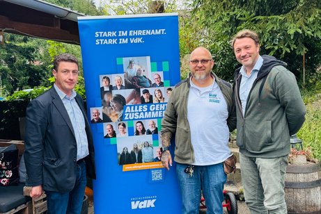 Menschen stehen vor einem Rollup mit der Aufschrift #allesgehtzusammen