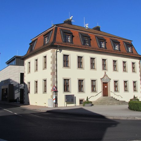 Das Foto zeigt das alte Forstamt am Lindenplatz von Neuhof. Heute dient das gut erhaltene Gebäude als Rathaus.