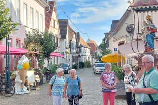 Blick in die Stadt mit Marienstatue und einigen Teilnehmern